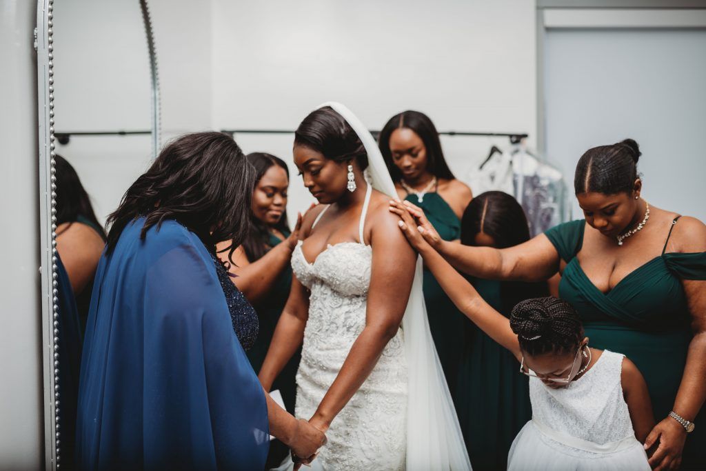 women pray over bride before wedding