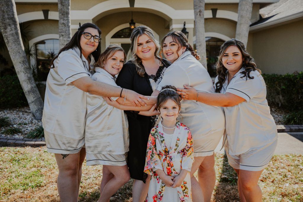 Hailee, bride, hugging her bridesmaids for a picture