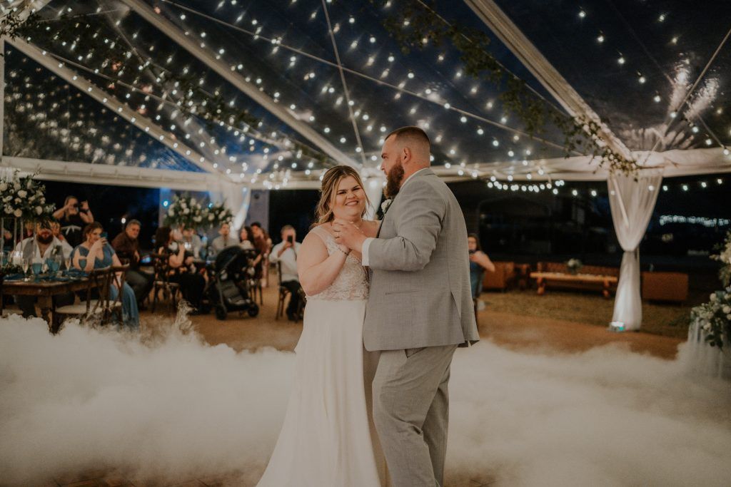 Happy couple during first dance surrounded by a cloud of fog on the dance floor