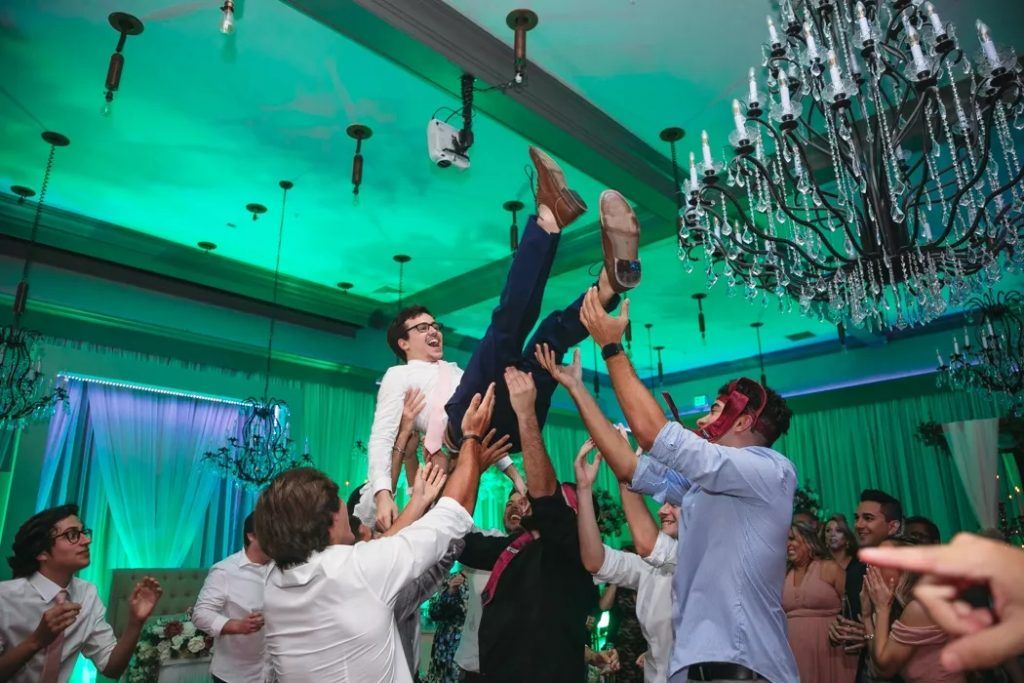 groom being lifted into the air by groomsmen on I Said Yes