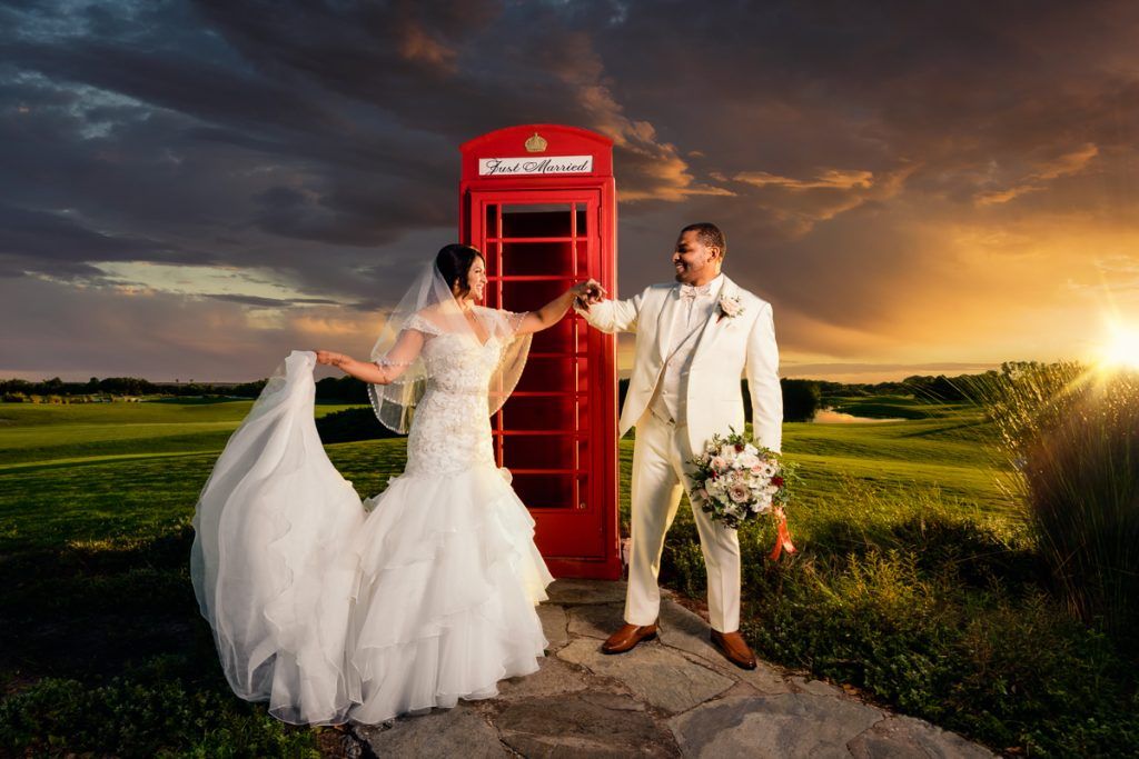 bride and groom smiling at each other in front of red telephone box on i said yes