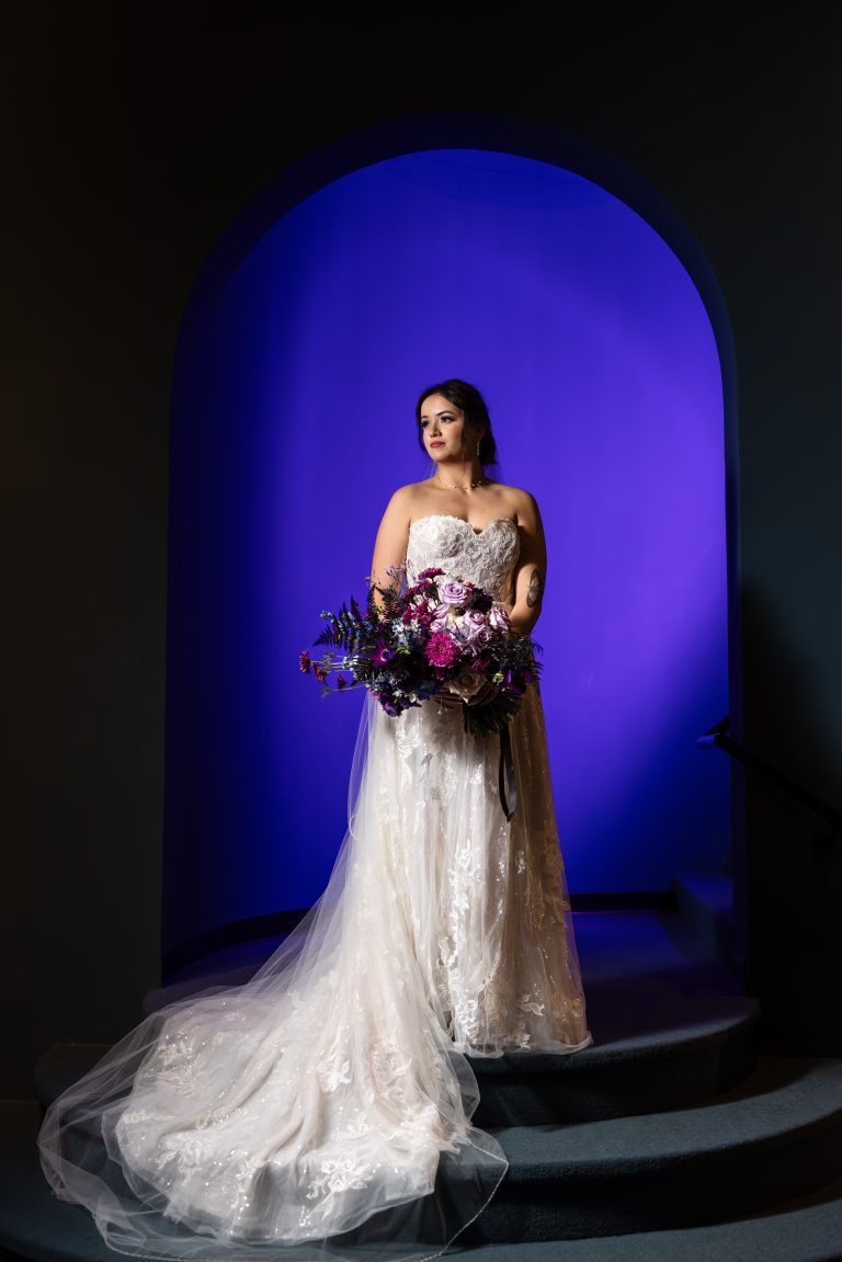 Celestial style bridal bouquet held by bride in front of dark blue background on I Said Yes! Fl