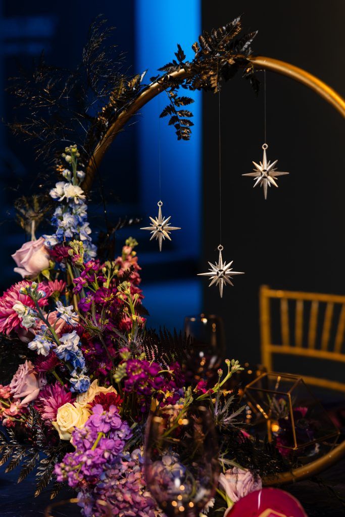 dark wedding florals with gold round centerpieces hung with small stars