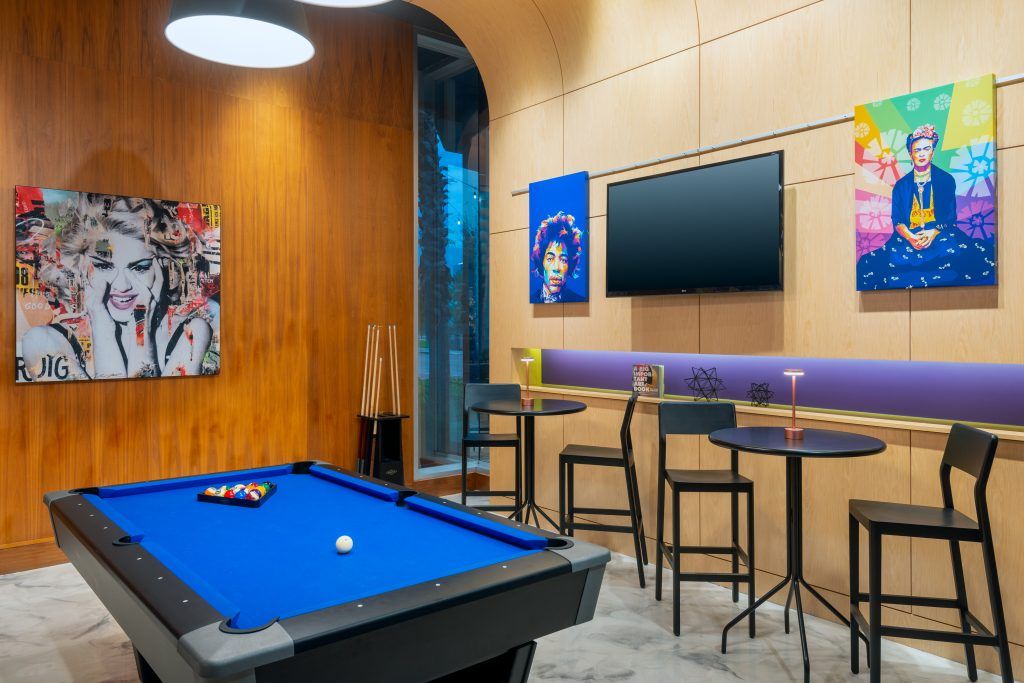 Pool table room at Aloft Orlando Downtown with vibrant wall art, ideal for Central Florida wedding venue pre-event entertainment