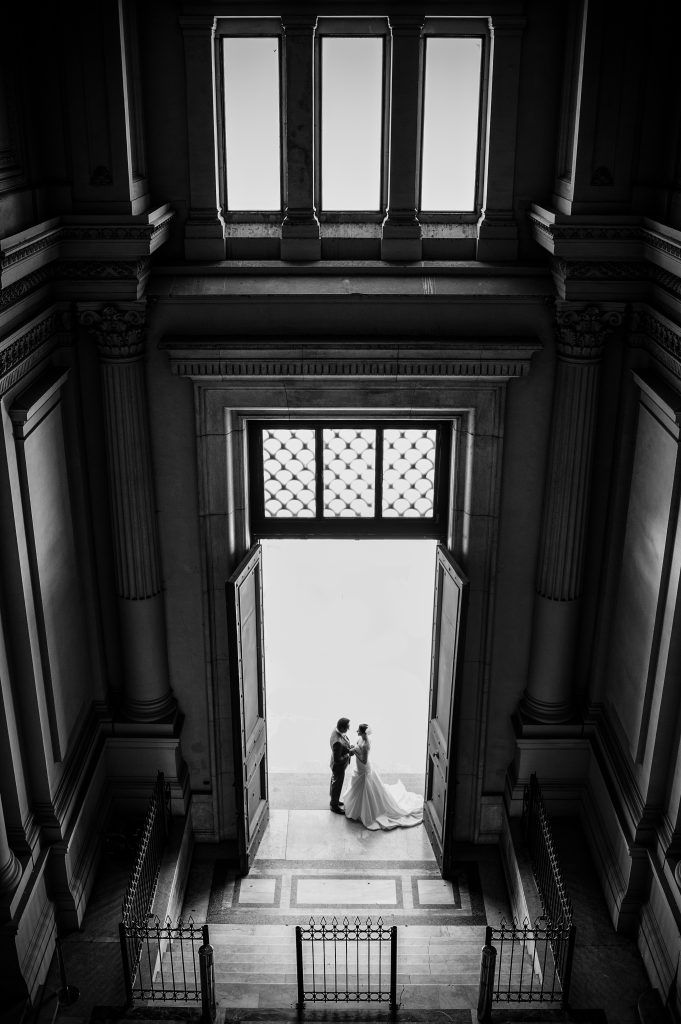 Black and white photo of married couple in a doorway by Lidia Fernandes Photography
