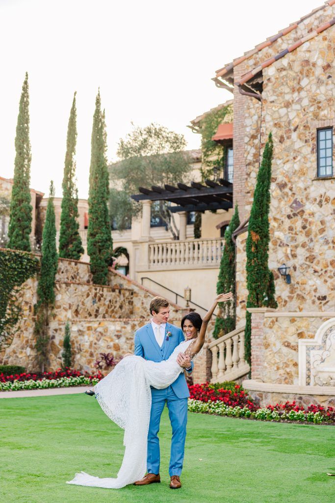 Groom holding bride in his arms at Bella Collina Wedding Venue in Florida