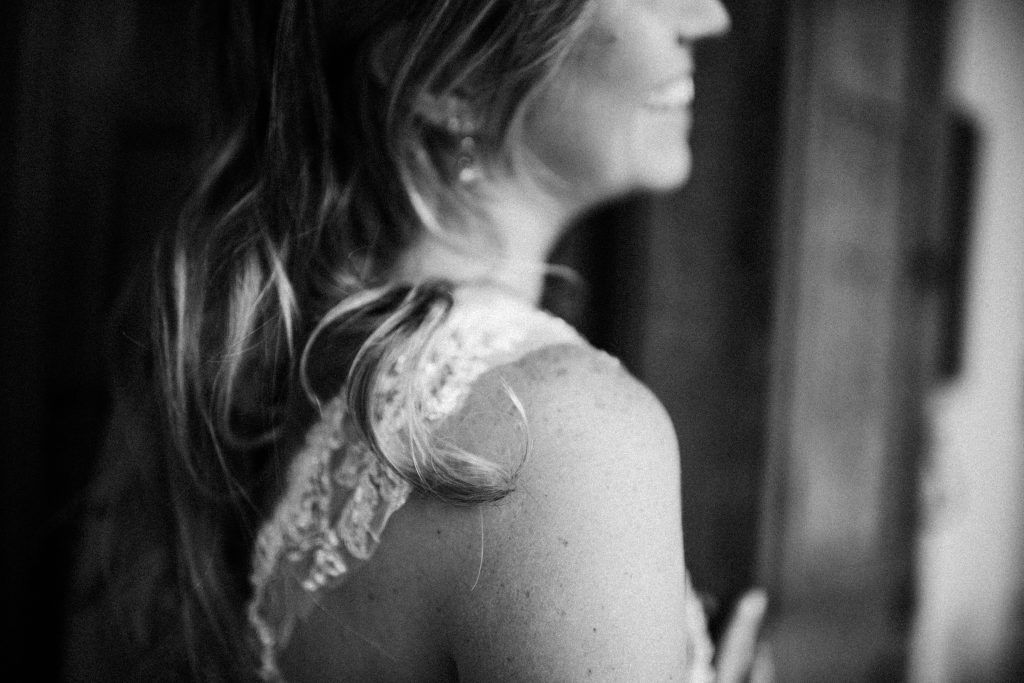 black and white photo of bride smiling and looking into the distance