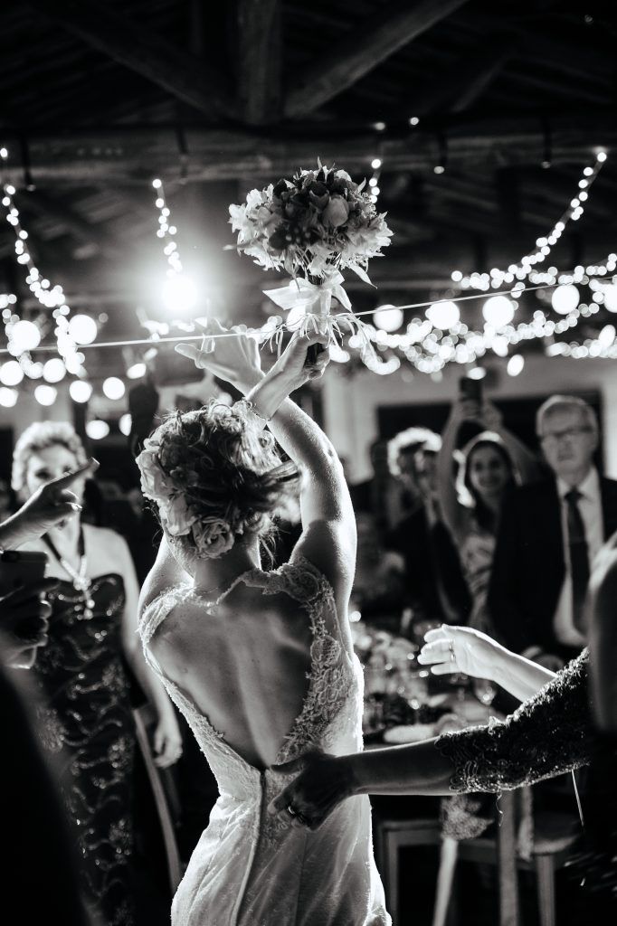 black and white photo of bride throwing her bouquet on I Said Yes! FL