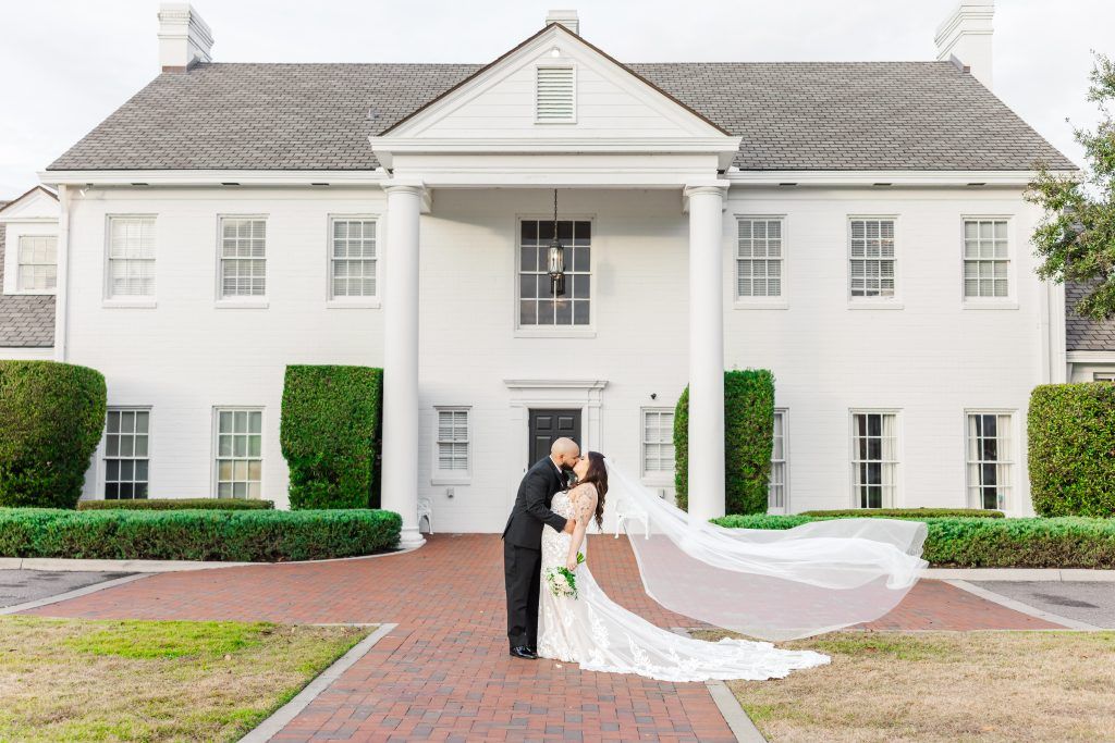 bride and groom kissing in front of wedding venue in Lake County Florida