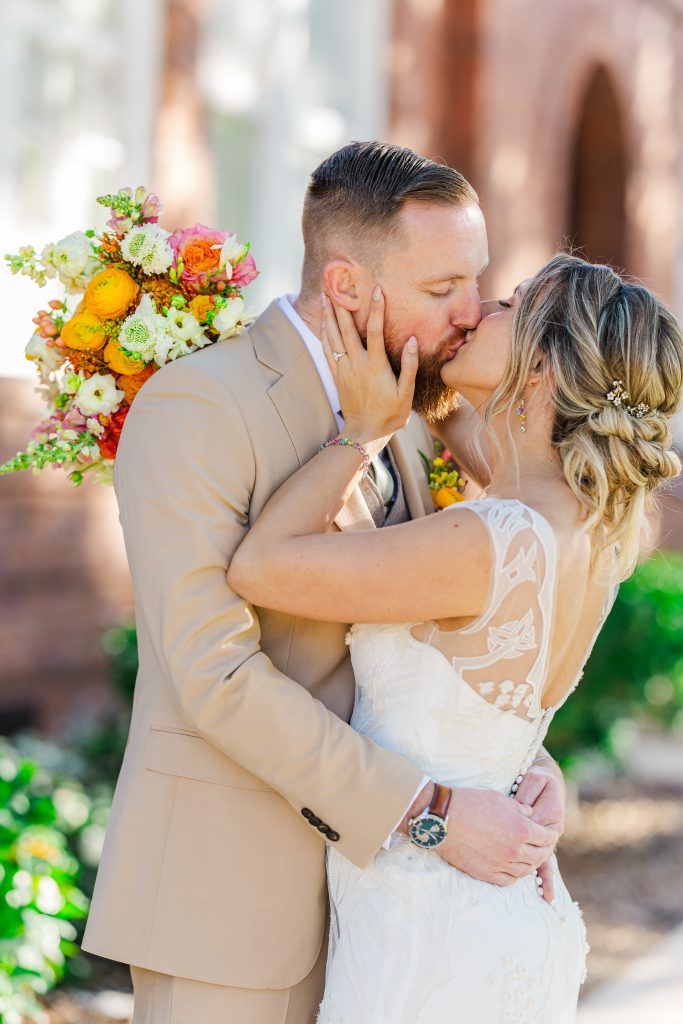 bride and groom kissing while holding each other
