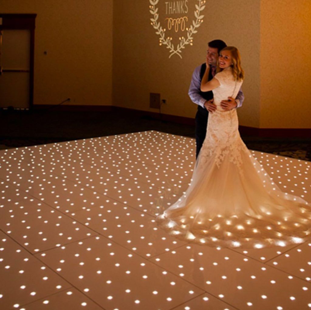 Bride and groom embracing on star light dance floor