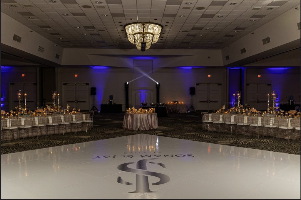Lavishly decorated ballroom at DoubleTree by Hilton Orlando set for an elegant wedding reception with custom monogrammed dance floor.
