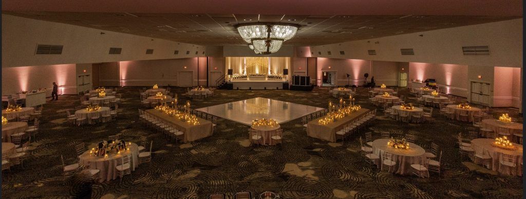 Wide view of a grand wedding reception setup at DoubleTree by Hilton Orlando with candlelit tables and a central dance floor.