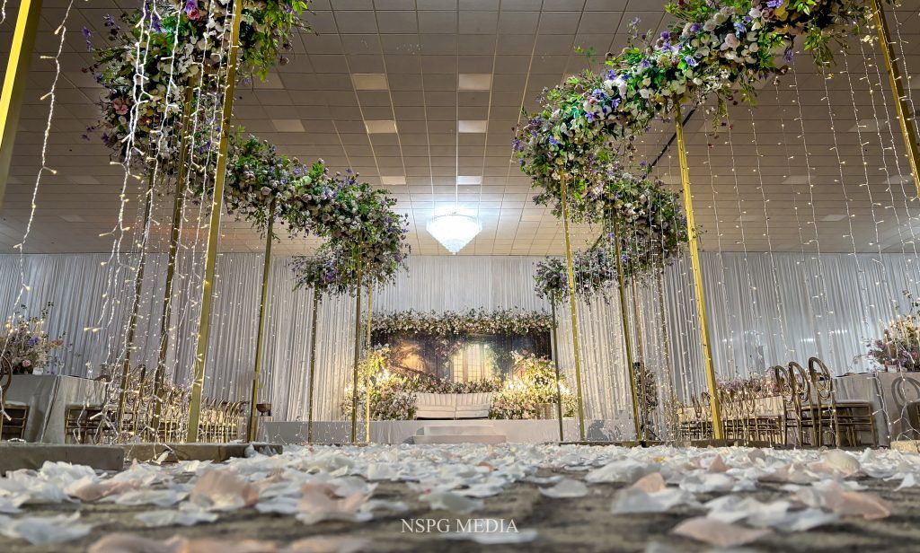 Romantic floral arch and draped lights create a magical indoor ceremony space at DoubleTree by Hilton Orlando.