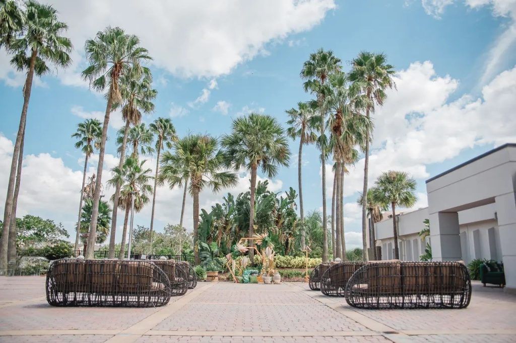Outdoor wedding ceremony setup with tropical landscaping and palm trees at DoubleTree by Hilton Orlando.
