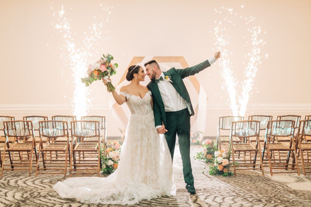 Bride and groom celebrate with sparklers in an indoor wedding ceremony space at DoubleTree by Hilton Orlando.