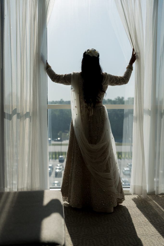 Bride looks out over Orlando from a hotel suite window at DoubleTree by Hilton Orlando.