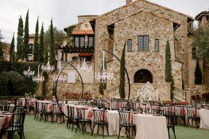 European market style wedding at Bella Collina on the courtyard with hanging chandeliers above long, winding wedding tables.