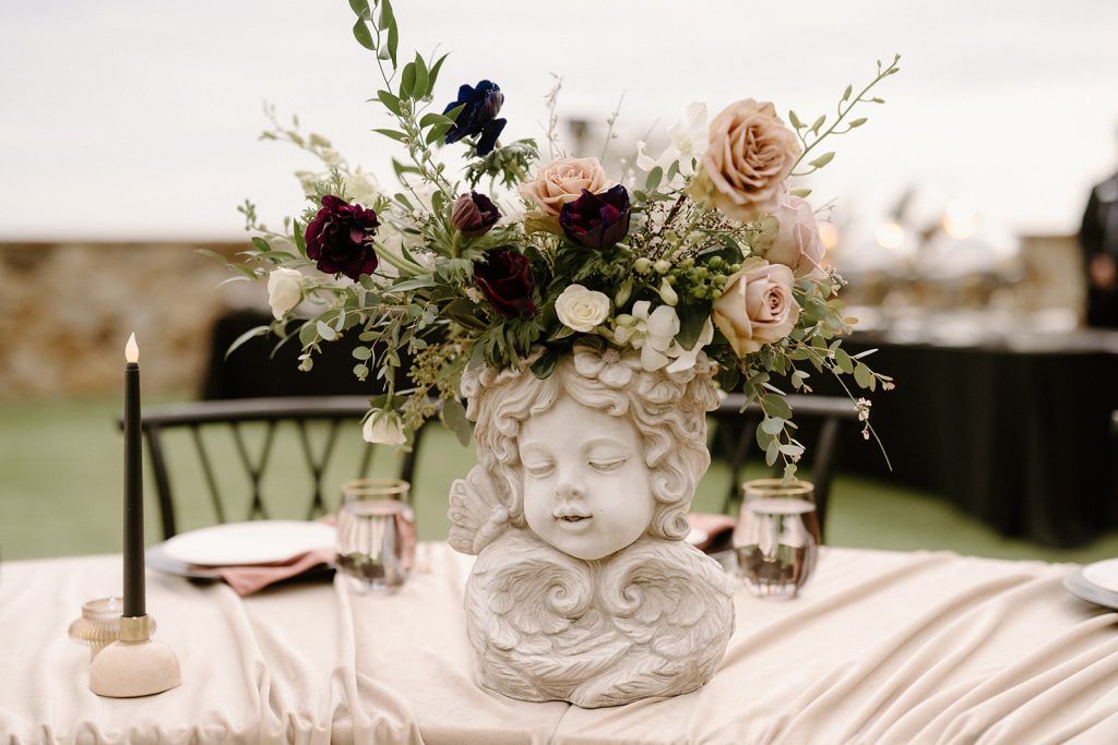 Unique angel floral centerpiece with moody blooms at luxury wedding at Bella Collina