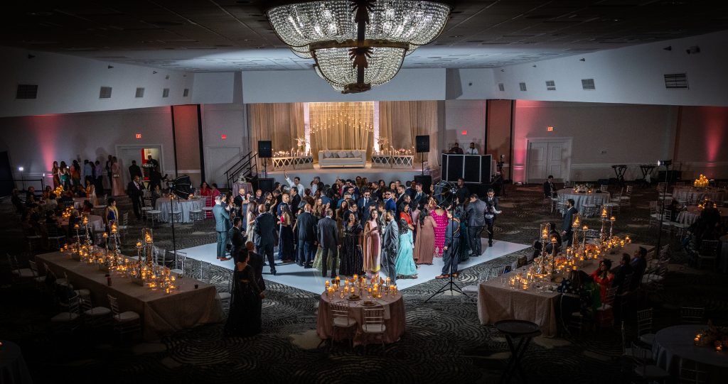 Wedding guests dance under a grand chandelier during a celebration at DoubleTree by Hilton Orlando.