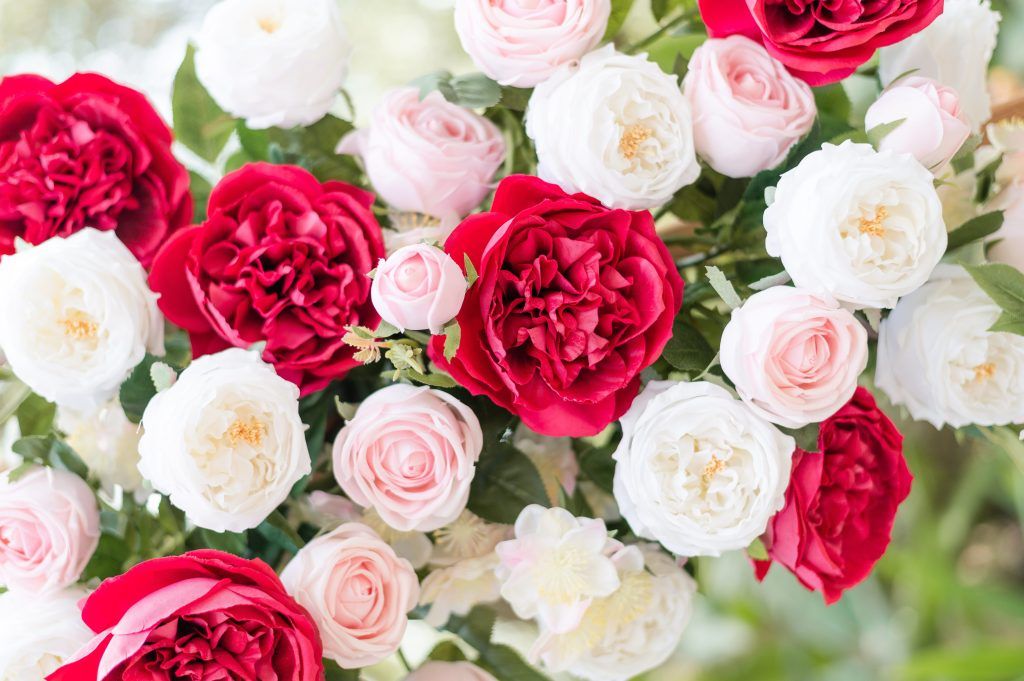 close-up view of red, pink, and white real-touch roses arranged for romantic weddings